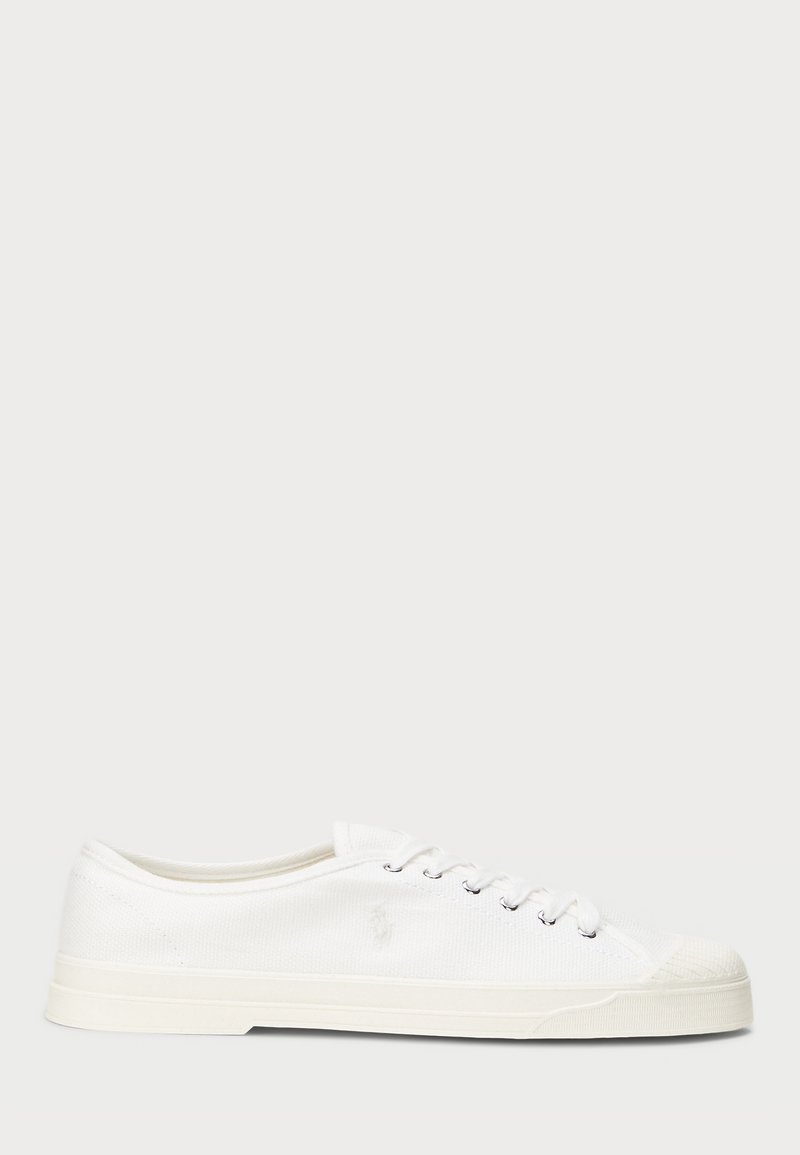 Λευκά καμβαδένια αθλητικά παπούτσια με στρογγυλή μύτη, κλείσιμο με κορδόνια και διακριτική λεπτομέρεια λογοτύπου. Διαθέτουν υφασμάτινη υφή και καουτσούκ σόλα.