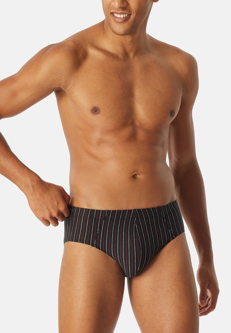 Schwarze Badehose mit vertikalen mehrfarbigen Streifen, mit konturiertem Schnitt und elastischem Bund. Glatte Stofftextur.