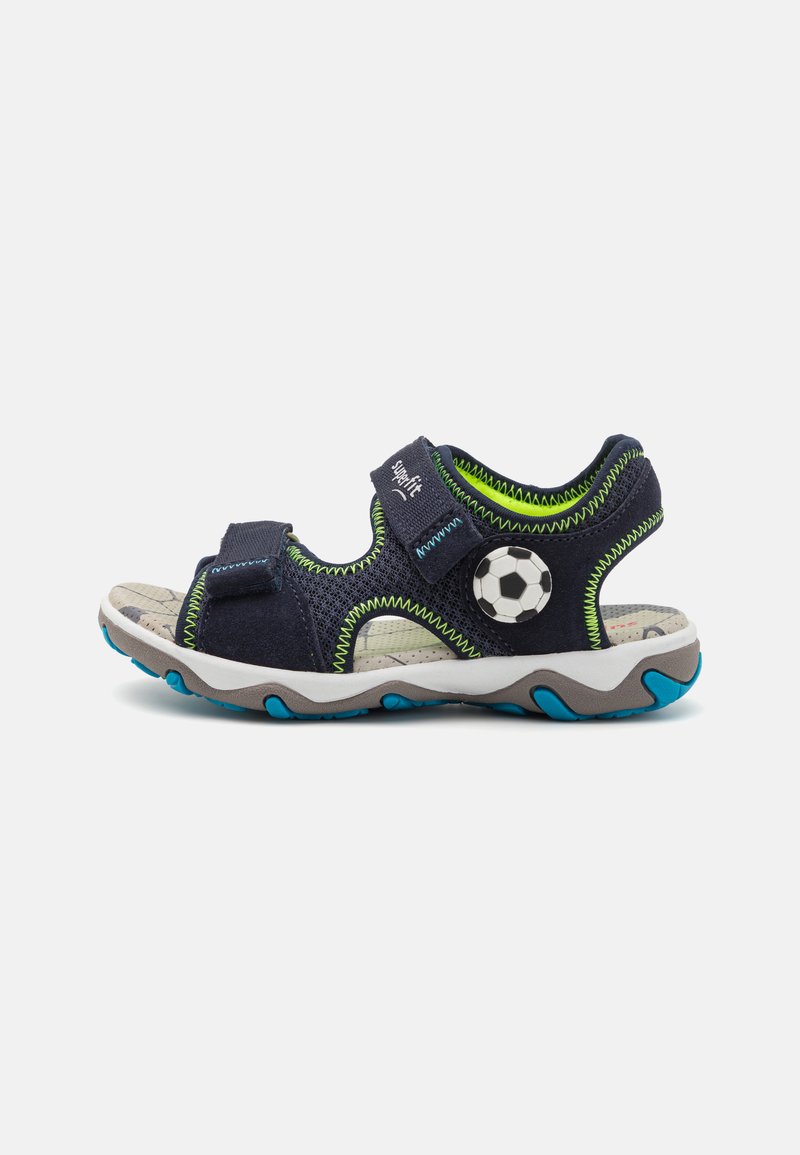 Navy blue children's sandals with green stitching, mesh panels, adjustable straps, and a soccer ball accent on the side. Rubber sole.