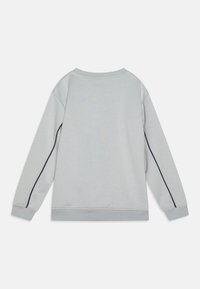 Sudadera gris claro de manga larga, con escote redondeado y detalle de raya lateral en color marino. Textura suave y puños y bajo de canalé.
