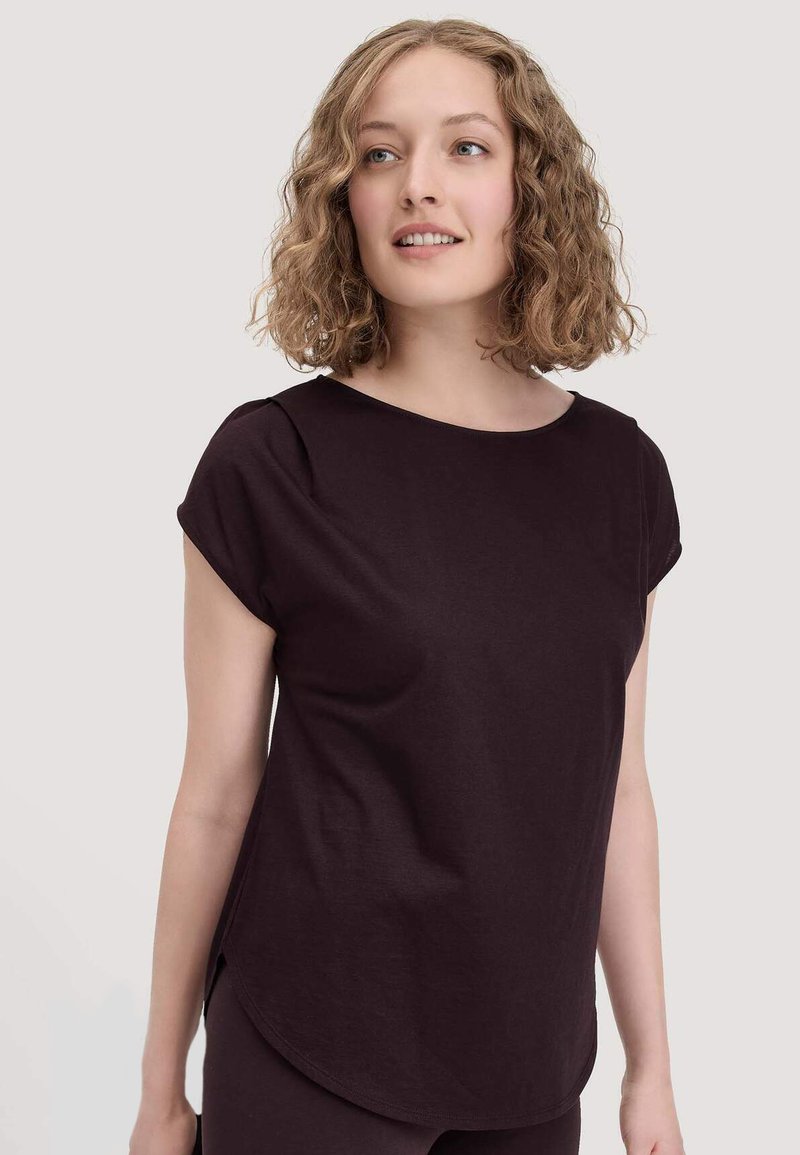 Donkerpaarse top met korte mouwen, een ronde halslijn, zijsplitten en een soepele textuur, ontworpen voor een ontspannen pasvorm.