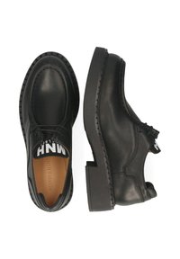 Scarpe in pelle nera con punta rotonda, suola in gomma spessa e lacci. Presentano un'etichetta con logo sulla linguetta e dettagli di cucitura visibili.