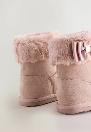 Botas de tobillo de ante rosa con un borde de piel sintética y un acento de lazo. Presentan una textura suave y una suela de goma resistente para mayor soporte.