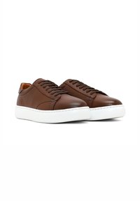 Bruine leren sneakers met een gestructureerde afwerking, witte rubberen zolen en een ronde neus. Voorzien van tonale veters en gestikte details.
