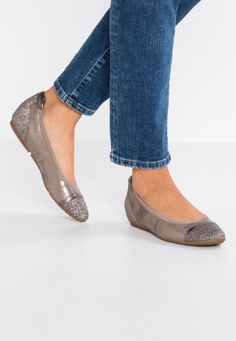 Ballerines en cuir taupe métallique, avec un bout argenté scintillant et des accents discrets à l'arrière. Semelle marron clair et flexible.