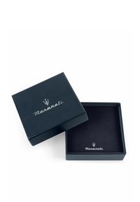 Scatola per gioielli in pelle blu navy con logo Maserati in argento, dotata di un morbido interno nero e di un design quadrato, parzialmente aperta.