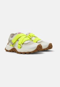 Leichte, weiße Sportschuhe mit neon-gelben Riemen, strukturierten Gummisohlen und verstärkter Zehenkappe. Mit einem atmungsaktiven Obermaterial aus Mesh.
