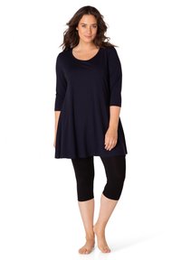 Marineblauwe tuniek met een ronde halslijn en driekwart mouwen, gecombineerd met zwarte capri leggings. Glad materiaal en vloeiende silhouet.