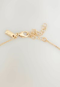 Gold-toned metal chain bracelet with a lobster clasp, featuring a rectangular tag with a small gem and elongated links for adjustability.