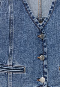 Denim vest featuring a V-neck design, five silver buttons, curved pockets, and contrasting orange stitching on a blue fabric.