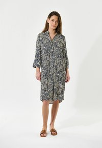 Abito camicia in navy con stampa botanica crema. Presenta maniche a tre quarti e una silhouette dritta, realizzato in tessuto leggero.