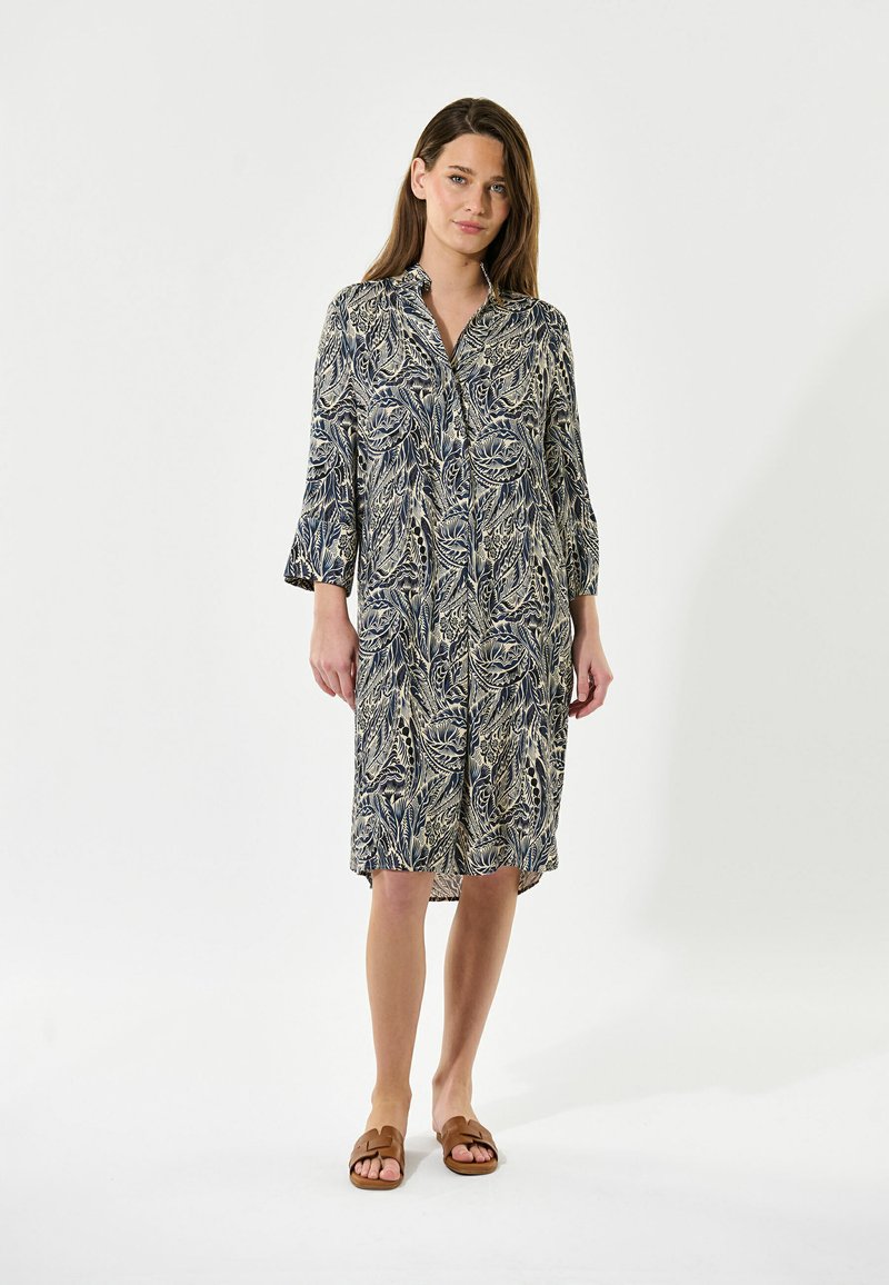 Abito camicia in navy con stampa botanica crema. Presenta maniche a tre quarti e una silhouette dritta, realizzato in tessuto leggero.