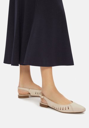 Beżowe baleriny typu slingback z gładkim, skórzanym wykończeniem, zaokrąglonym noskiem, wzorem wycięć po bokach oraz niewielkim, klockowym obcasem.