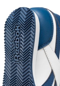 Blauwe en witte sneaker met een gestructureerde rubberen zool met een visgraatpatroon en een verhoogd "Reebok"-logo aan de zijkant.