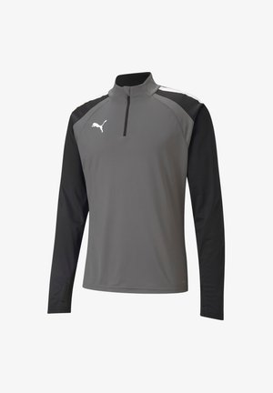 Haut de performance gris à manches longues avec des manches noires, col zippé moitié, et logo blanc sur la poitrine, fabriqué en matériau respirant et avec un design texturé.