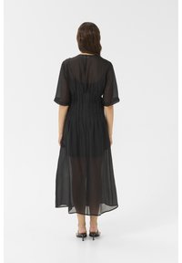 Black sheer maxi dress with mid-length sleeves, ruched back design, and a flowing, lightweight texture.