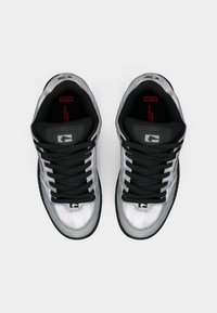 Pair of silver and black sneakers with black laces viewed from above on a white background, showing brand logos inside.