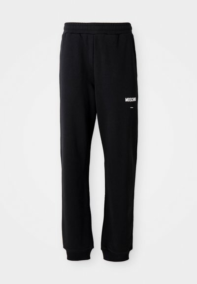 Svarta joggingsbyxor med avslappnad passform, tillverkade av mjukt tyg. Har resår i midjan och vit "Moschino"-logotyp på vänster lår.