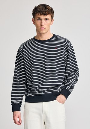 Marineblauwe en witte gestreepte sweatshirt met ribgebreide manchetten en halslijn. Bevat een klein rood logo op de borst. Zachte katoenen stof.