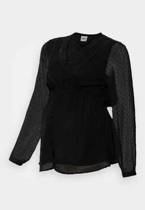 Black maternity blouse with sheer dotted long sleeves, buttoned front, V-neckline, and gathered waist detail.