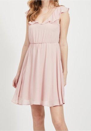 Robe rose clair en chiffon avec des manches à volants, un décolleté en V et une taille élastique ; elle tombe doucement jusqu'aux genoux.