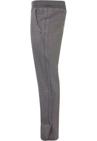 Pantalons de jogging gris avec une taille élastique, poches latérales, coupe droite et détails de couture visibles le long des côtés.