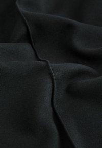 Black fabric with a smooth texture, featuring subtle folds and a consistent color, suggesting stretchability and durability.