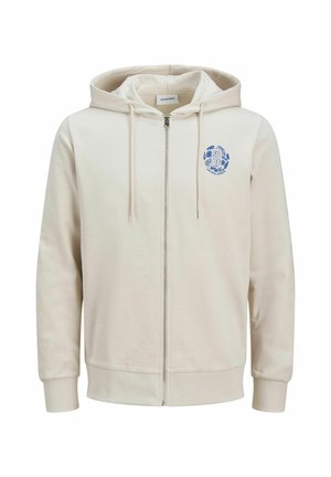 Beige zip-hoodie lavet af blødt stof, har en hætte med snøre, ribbede manchetter og et blåt rundt logo på venstre bryst.