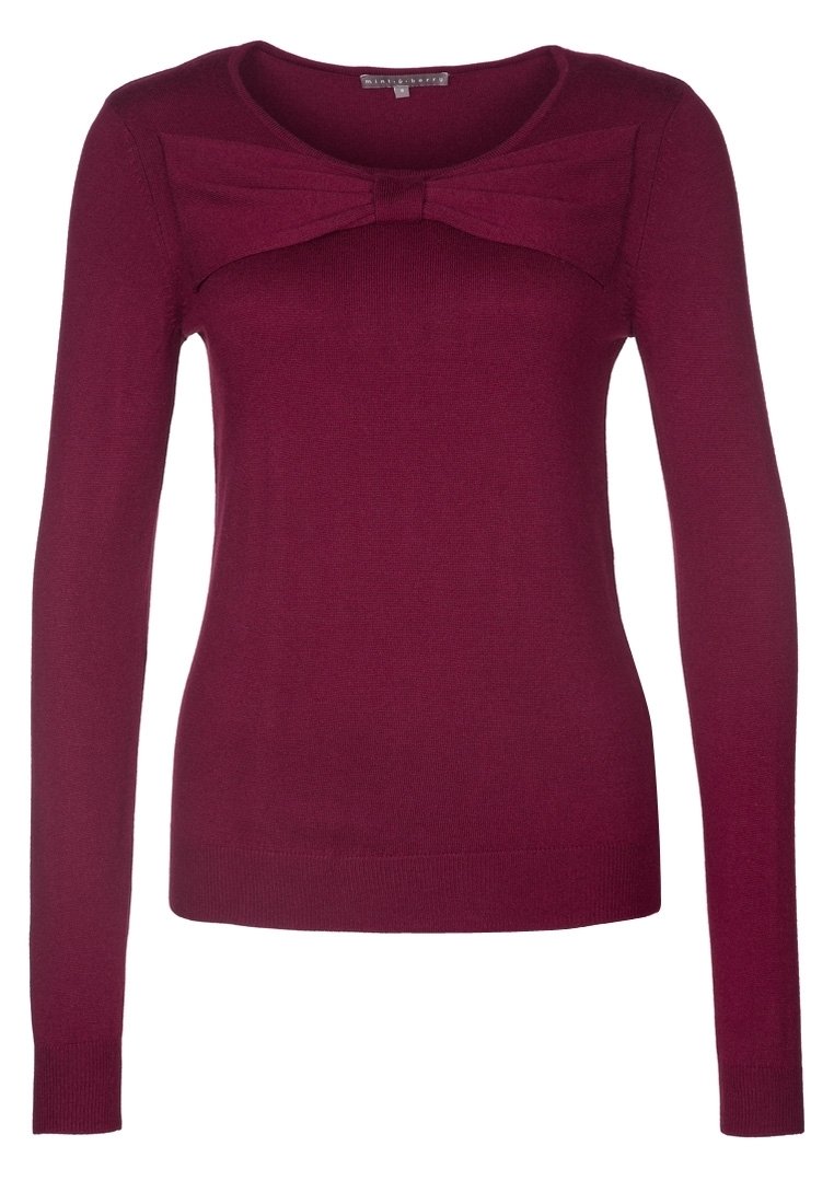 Maglione bordeaux con maniche lunghe, scollo rotondo e dettaglio a fiocco sul petto. Realizzato in tessuto morbido e elasticizzato con una silhouette aderente.