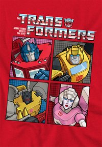 Red T-shirt featuring a graphic design of four Transformers characters in quadrants: blue, red, yellow, and pink, with bold outlines and distinct features.