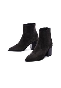 Bottines en suède noir avec des orteils pointus et un talon empilé. Dotées d'une couture verticale subtile et d'un détail de design de style western.