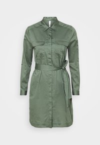 Abito camicia verde oliva a maniche lunghe con chiusura anteriore a bottoni, due tasche sul petto e cintura in vita.