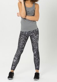 Top sin mangas gris con un diseño ajustado, combinado con leggings de leopardo en tonos gris y negro. La tela parece elástica con una textura suave.
