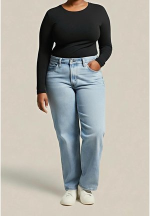 Woman wearing a fitted black long-sleeve shirt, light blue straight-leg jeans, white shoes, with one hand in pocket against plain background.