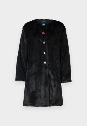 Melnas mākslīgās ādas mētelis ar apaļu izgriezumu, garām piedurknēm un krāsainiem dārgakmeņu līdzīgiem pogām priekšpusē. Mīksta tekstūra un vidēja garuma dizains.