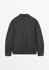 Dark gray long-sleeve jacket with elasticated waistband and cuffed sleeves, shown from the back on a white background.