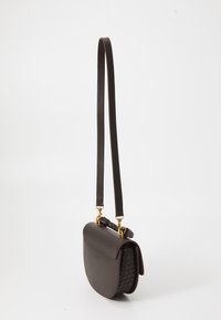 Sac bandoulière en cuir marron avec une forme incurvée, texture tressée sur le côté, quincaillerie dorée et une longue sangle ajustable.