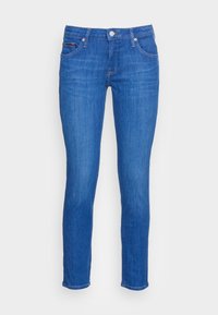 Blå denimjeans med slim fit, fem fickor och knappstängning. Slät yta med subtila blekningar och sömnadsdetaljer.
