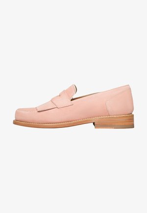 Mocassin en daim rose clair avec un bout arrondi et des détails cousus ; il dispose d'un talon en bois plat et empilé ainsi que d'un dessus lisse et texturé.