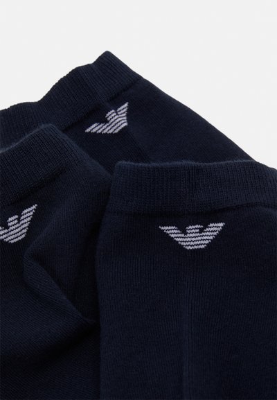 Calcetines de algodón azul marino con un logo blanco en el puño. Textura suave con bordes acanalados y un diseño clásico de longitud media.