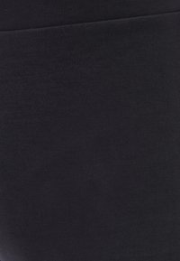 Černá elastická tkanina s hladkým povrchem, která nabízí těsný střih a minimální švy, vhodná pro přiléhavé oblečení.