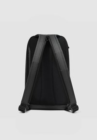 Mochila negra con tela texturizada, correas acolchadas para los hombros y cierres dobles con cremallera. El diseño simple enfatiza la funcionalidad.
