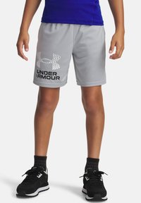 Pelēki sporta šorti, kas izgatavoti no viegla materiāla, ar teksturētu logo un melnu uzrakstu "UNDER ARMOUR". Valkāti ar melniem sporta apaviem.