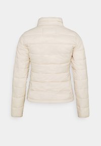 Nafouknutá krémová bunda s vysokým límcem, horizontálním prošíváním, hladkým povrchem a bez viditelného kování, pohled z profilu.