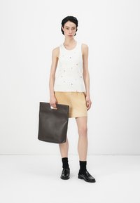 Witte tanktop met multicolor stippen, beige rok, zwarte leren tas en schoenen. Geweven stof en een eenvoudig ontwerp met een minimalistische esthetiek.
