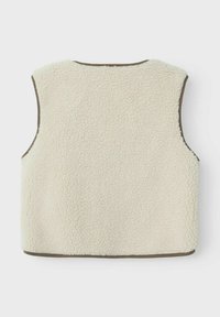 Gilet en polaire de couleur blanc cassé avec une surface texturée, sans manches, et avec une bordure marron autour de l'encolure et des bords.