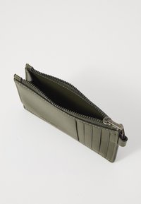 Olive green leather wallet with zipper closure, featuring a smooth texture and subtle stitched accents. Interior is unlined, showing ample space.
