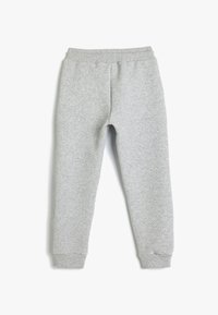 Grijze trainingsbroek van gemêleerd materiaal, met een elastische tailleband en aansluitende boorden bij de enkels. Eenvoudig ontwerp en neutrale kleur.