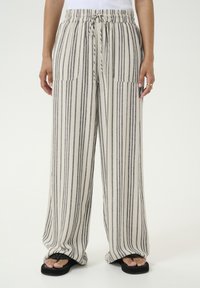 Pantalons larges rayés en crème et gris, dotés d'une taille élastique avec cordon de serrage et de deux poches avant. Tissu doux et respirant.