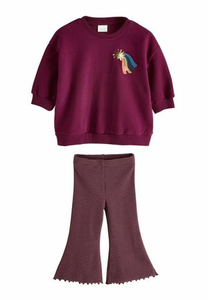 Børneoutfit med en vinrød sweatshirt med et stjerne- og regnbuedesign, kombineret med vinrøde og lyserøde stribede vidde bukser.